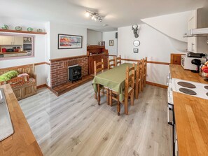 A compact kitchen with a dining area, a fireplace, and a small living space. - 10 The Apostles - UK37312 (Lochranza)
