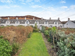 A row of white houses with a grassy pathway leading to the entrance.