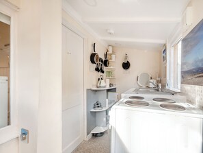 A compact kitchen with a washing machine, a sink, and a window with a view. - Apostles Back House - UK37313 (Lochranza)
