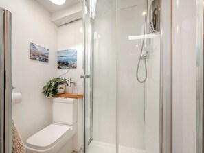 A modern bathroom with a glass-enclosed shower, a toilet, and two framed landscape paintings on the wall. - Apostles Back House - UK37313 (Lochranza)