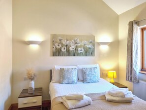 A neatly arranged bedroom with a bed, pillows, a bedside table, a lamp, and a painting on the wall. - Westfield Courtyard - UK50704 (Fitling, near Burton Pidsea)