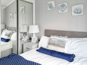 Ein Hotelzimmer mit Bett, Nachttischen, Lampen und Bildern an der Wand.