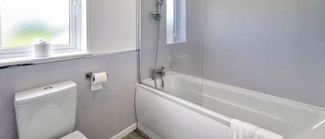 A modern bathroom with a toilet, a shower with a glass door, and a bathtub.