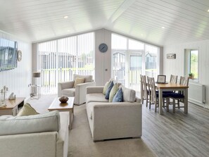 A spacious living room with a high ceiling, large windows, and a view of the backyard. - Cherry Blossom 38 - UK50707 (Fitling, near Burton Pidsea)