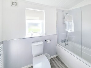 Un baño moderno con inodoro, bidé y ducha con mampara de vidrio.