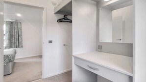 A modern bathroom with a white vanity, a mirror, and a hanging shower curtain.