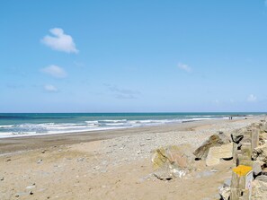 A beach with a rocky shoreline and a wooden fence. - 3 bedroom accommodation in Llanon, near Aberaeron (Llanon, near Aberaeron)