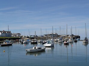 A marina with various boats docked, a clear sky, and buildings in the background. - 3 bedroom accommodation in Llanon, near Aberaeron (Llanon, near Aberaeron)