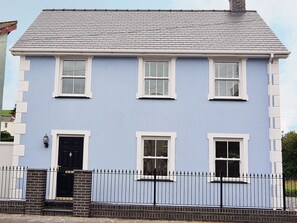 A two-story building with a light blue facade, white window frames, and a black door. - 3 bedroom accommodation in Llanon, near Aberaeron (Llanon, near Aberaeron)