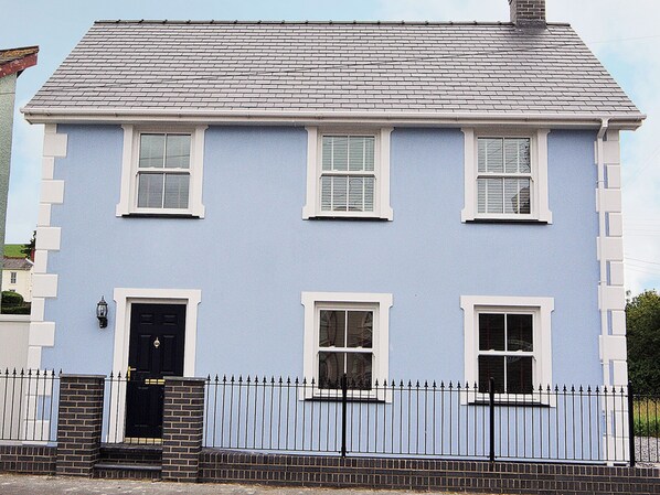 A two-story building with a light blue facade, white window frames, and a black door. - 3 bedroom accommodation in Llanon, near Aberaeron (Llanon, near Aberaeron)