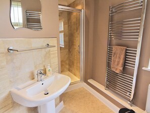 A bathroom with a sink, mirror, shower, and towel rack. - 3 bedroom accommodation in Llanon, near Aberaeron (Llanon, near Aberaeron)
