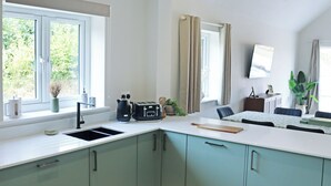 Eine moderne Küche mit integriertem Spülbecken, einer Kaffeemaschine und einem Toaster.