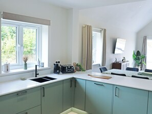 Eine moderne Küche mit integriertem Spülbecken, einer Kaffeemaschine und einem Toaster.