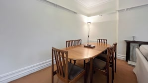 A dining room with a wooden table and chairs, a floor lamp, and a fireplace.