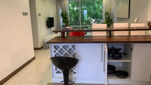 Una cocina moderna con encimera de madera, armarios blancos y estufa integrada.