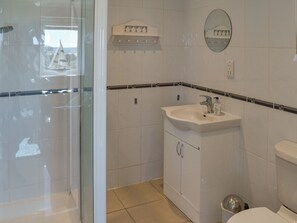 A bathroom with a glass shower enclosure, a sink with a mirror, and a toilet. - 2 bedroom accommodation in Althorne, near Chelmsford (Althorne, near Chelmsford)