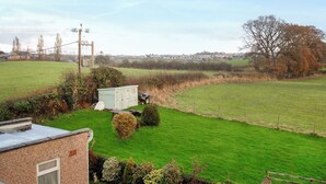 A rural landscape with a green field, a small shed, and a house with a sloped roof. - 3 bedroom accommodation in Llandundo Junction (Llandundo Junction)