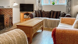 A living room with a TV, sofa, and a fireplace. - 3 bedroom accommodation in Ibberton, near Blandford Forum (Ibberton, near Blandford Forum)