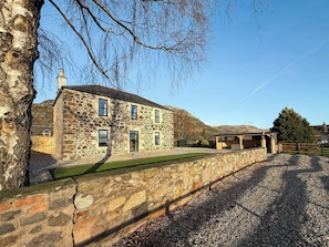A stone building with multiple windows, a gravel driveway, and a grassy area. - Blairmains Farmhouse (Stirling)