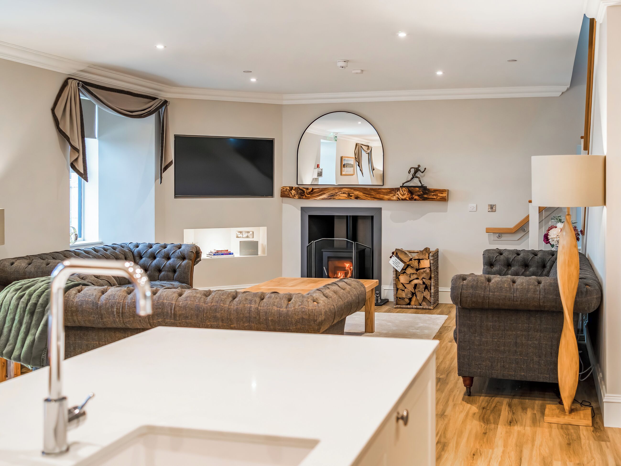 Ein modernes Wohnzimmer mit Kamin, Flachbildfernseher und Sofa.