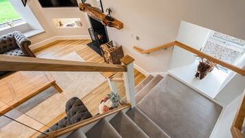 A modern interior with a staircase, a fireplace, and a sofa.