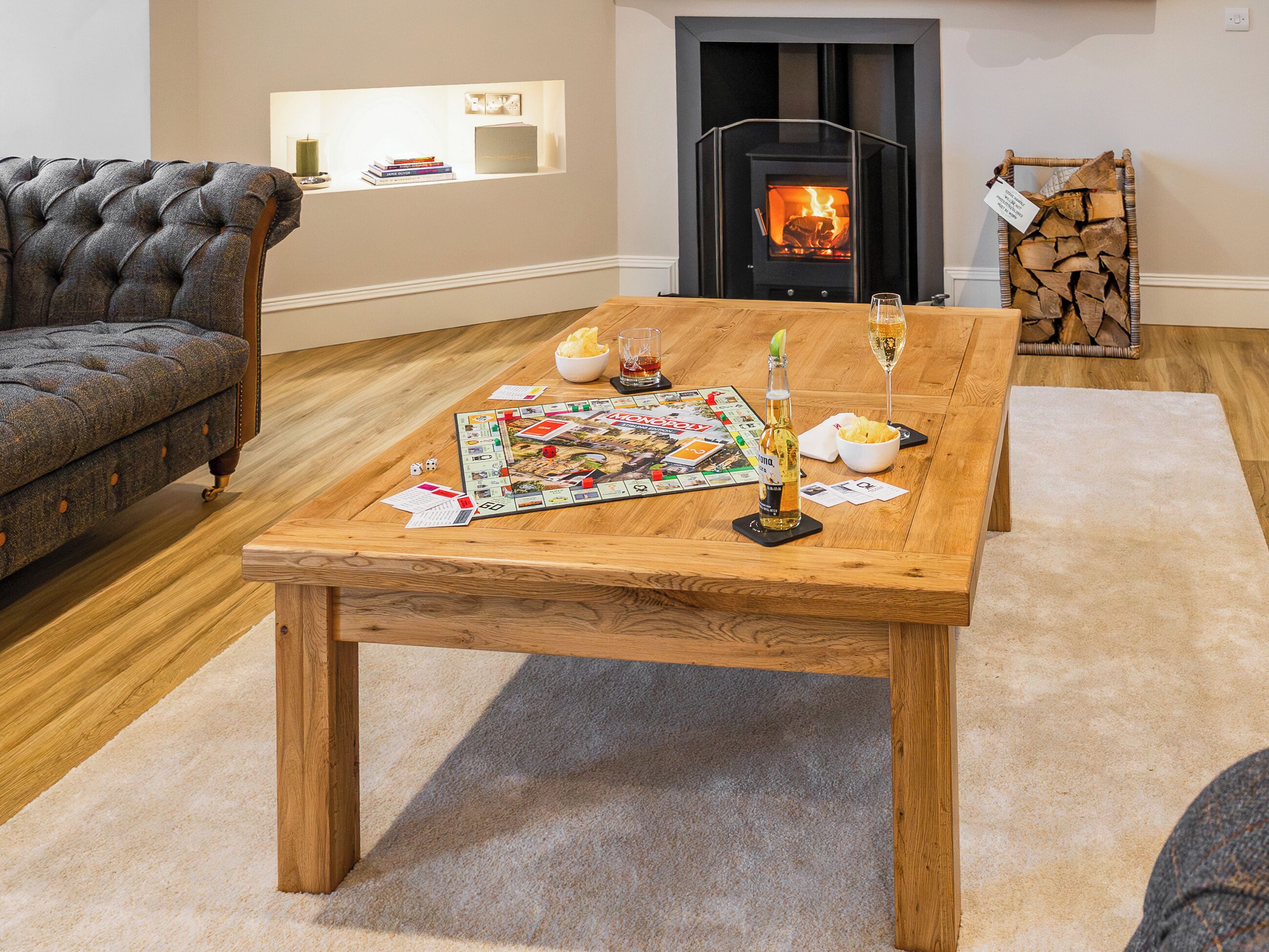 A cozy living room with a fireplace, a wooden coffee table, and a plush sofa.