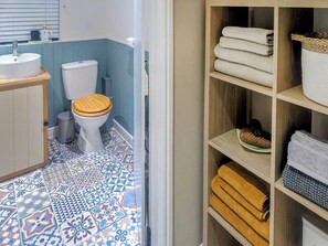 Un baño con inodoro, lavamanos y baldosas de suelo con diseño.