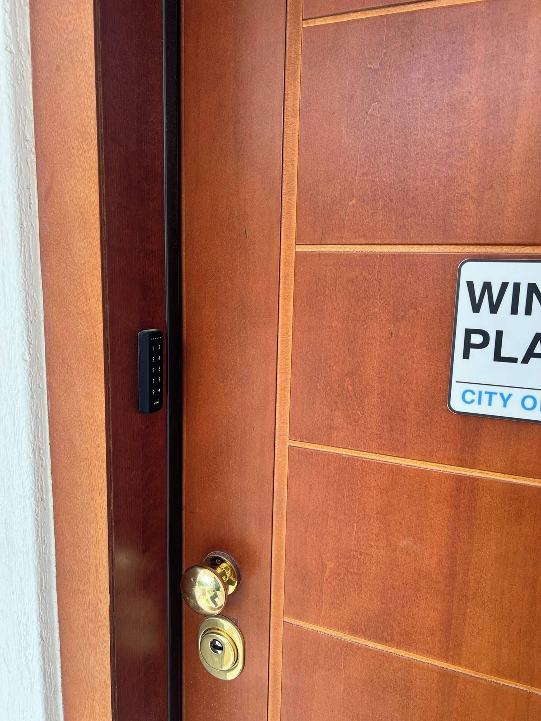 A wooden door with a keypad lock and a keyhole.