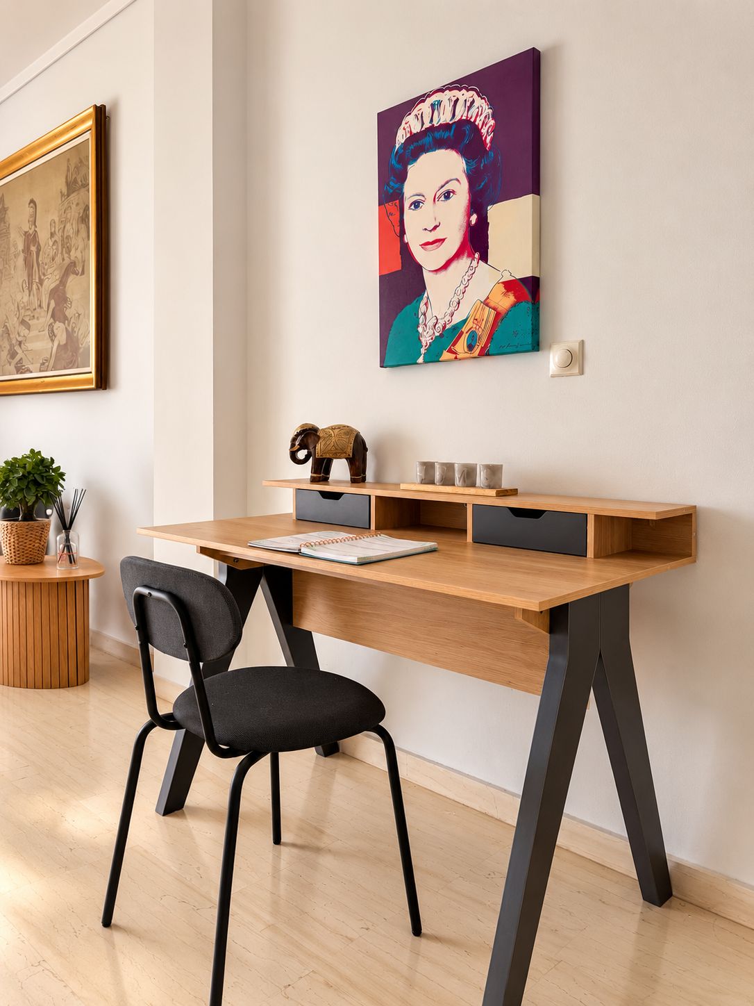 A modern office space with a wooden desk, black office chair, and a painting of a woman on the wall.