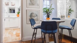 A modern dining area with a white table, blue chairs, and a potted plant. - 2 bedroom accommodation in Whitby (Whitby)