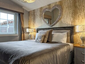 A bedroom with a large bed, a heart-shaped mirror, and two bedside lamps. - 2 bedroom accommodation in Glasgow (Glasgow)