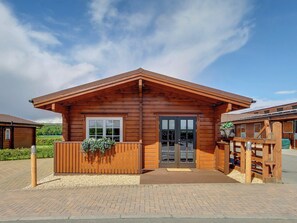 A wooden cabin with a pitched roof, a front door, and a small porch. - 2 bedroom accommodation in Glasgow (Glasgow)