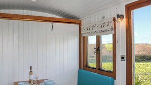 Quarto com mesa de madeira e banco acolchoado azul.