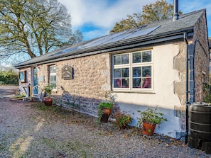 A stone building with a sign reading 'Wolf House Gallery,' a window, and potted plants. - 2 bedroom accommodation in Silverdale (Silverdale)