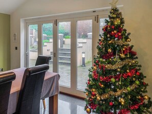 Ein Essbereich mit einem Weihnachtsbaum, dekoriert mit Schmuck und Lichterketten.