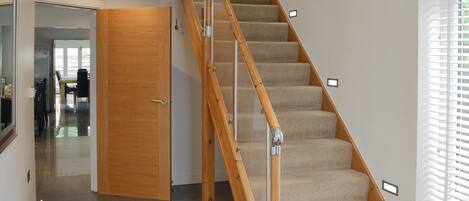 A wooden staircase with carpeted steps leading to a landing.