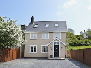 A two-story house with a front porch, a chimney, and a gravel driveway. - 6 bedroom accommodation in Llanon, near Aberaeron (Llanon, near Aberaeron)