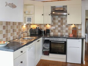 A compact kitchen with a sink, toaster, kettle, oven, and a small refrigerator. - 1 bedroom accommodation in Llanfaethlu, near Church Bay (Llanfaethlu, near Church Bay)