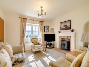 A cozy living room with a fireplace, comfortable seating, and a television. - Manor House Farm - UK49536 (Troutsdale near Scarborough)