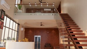 Un hall d’entrée spacieux avec un plafond haut, un escalier et un comptoir d’accueil.