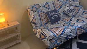 A cozy living room with a patterned sofa, a small side table with a lamp, and three motivational wall art pieces. - Tranquil 1-bedroom condo with AC in Pasay City (Pasay City)