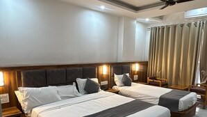 A hotel room with a large bed, two bedside tables, a ceiling fan, and a view of the outdoors. - HOTEL FALLS STREET BY DC HILLS (Rishikesh)
