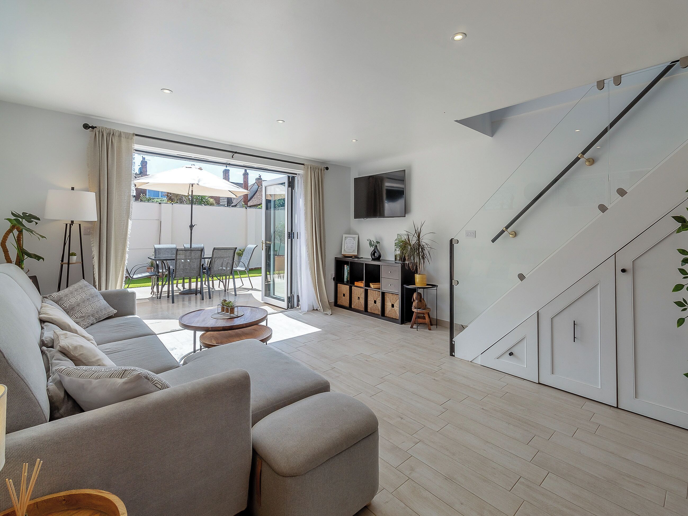 Ein modernes Wohnzimmer mit einer Couch, einem Couchtisch und einem an der Wand befestigten Fernseher.