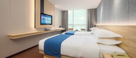 Habitación de hotel con una cama, televisor montado en la pared, escritorio de madera y ventana con cortinas.