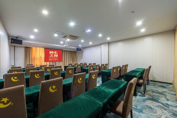 A conference room with rows of tables and chairs, a projector screen, and a red banner. - Winsome Hotel Guangzhou Tianhe South China Normal University Metro Branch (Guangzhou)