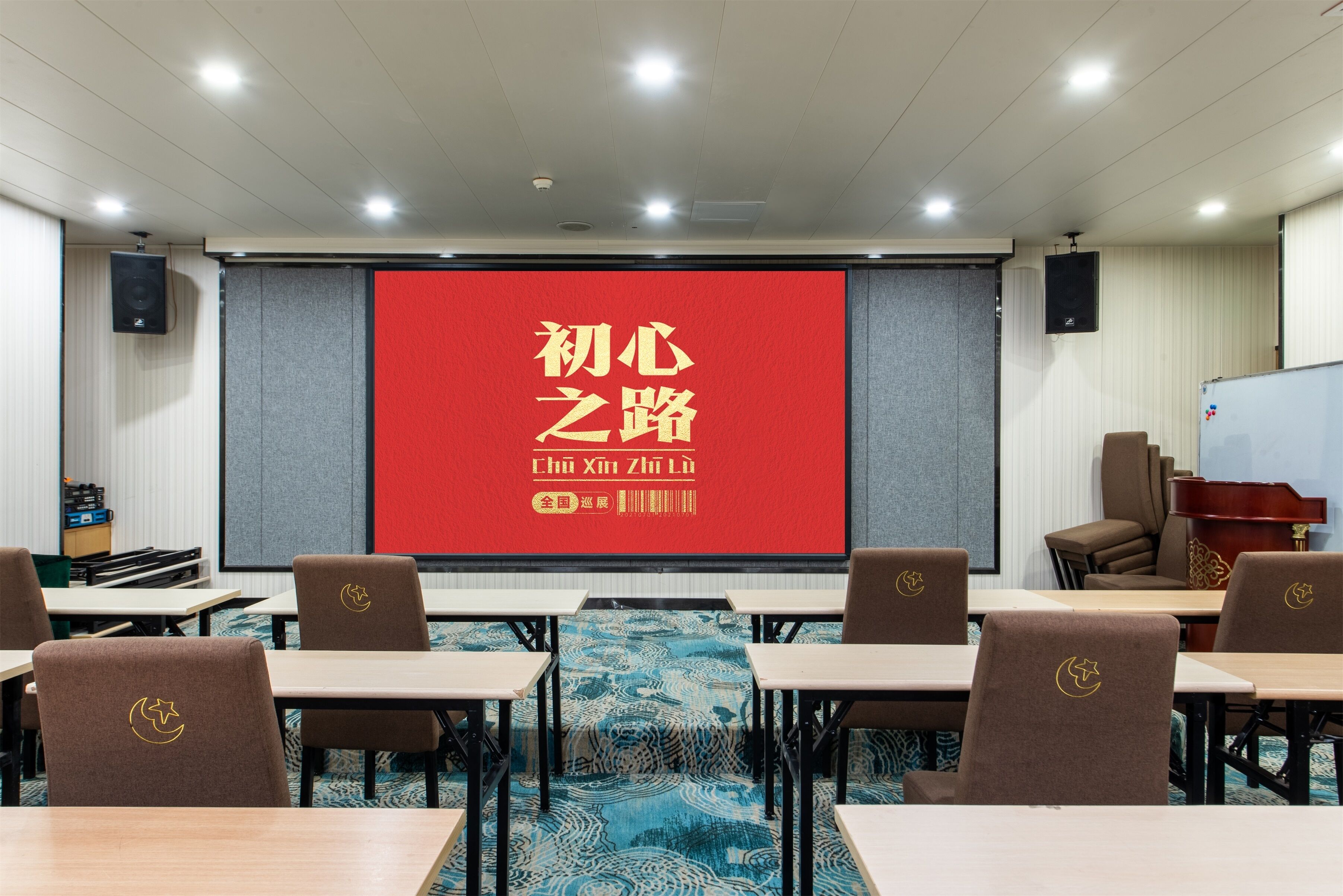 Un salón de conferencias con una pantalla roja mostrando caracteres chinos, mesas, sillas y una pizarra.