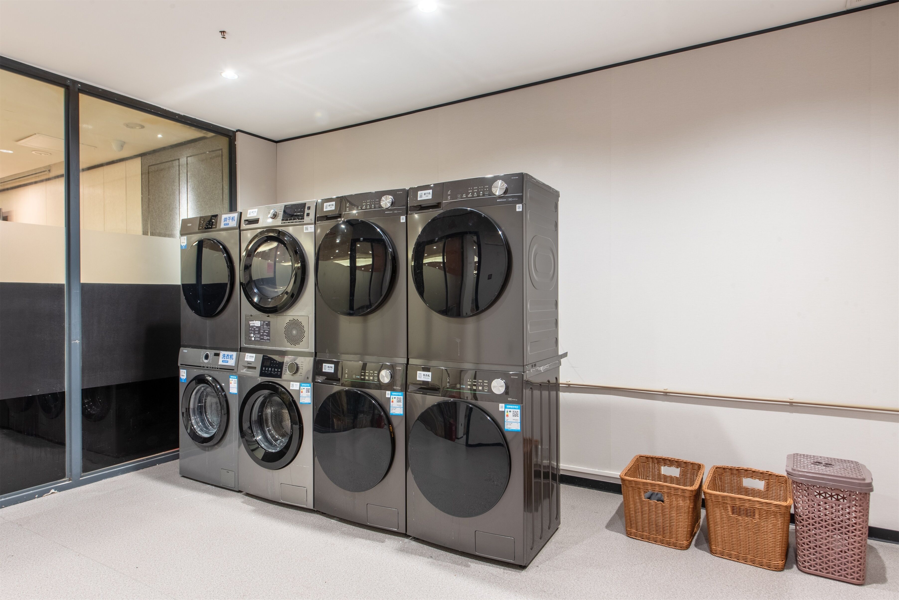 A laundry facility with multiple washing machines and baskets.