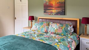 A bedroom with a bed, a painting, and two bedside lamps. - 3 bedroom accommodation in Lochranza (Lochranza)