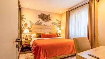 A hotel room with a bed, a chair, a nightstand, and a lamp.