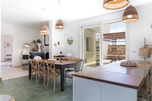 A modern kitchen with a central island, wooden chairs, and hanging wicker pendant lights. - Villa in Lizzanello with 5 bedrooms sleeps 10 (Lizzanello)
